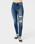 A person wearing blue skinny jeans with distressed rips on the thighs and knees, paired with black low-top sneakers, photographed against a light gray studio background.