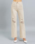 Beige distressed jeans on a gray background