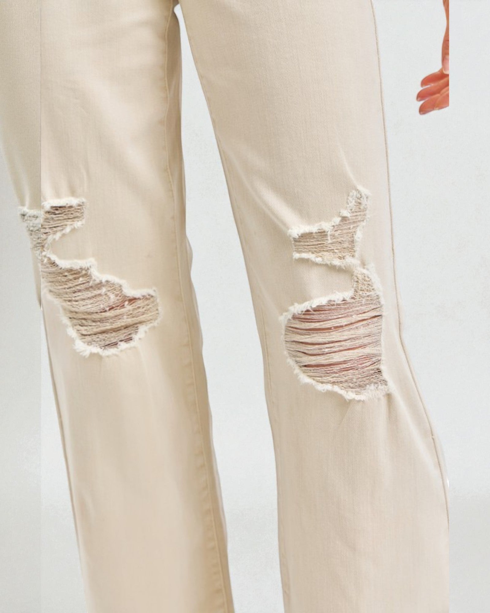 Beige distressed jeans on a white background