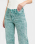 Teal acid-wash jeans worn by a person on a white background