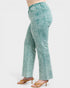Teal acid-wash jeans worn by a person on a white background