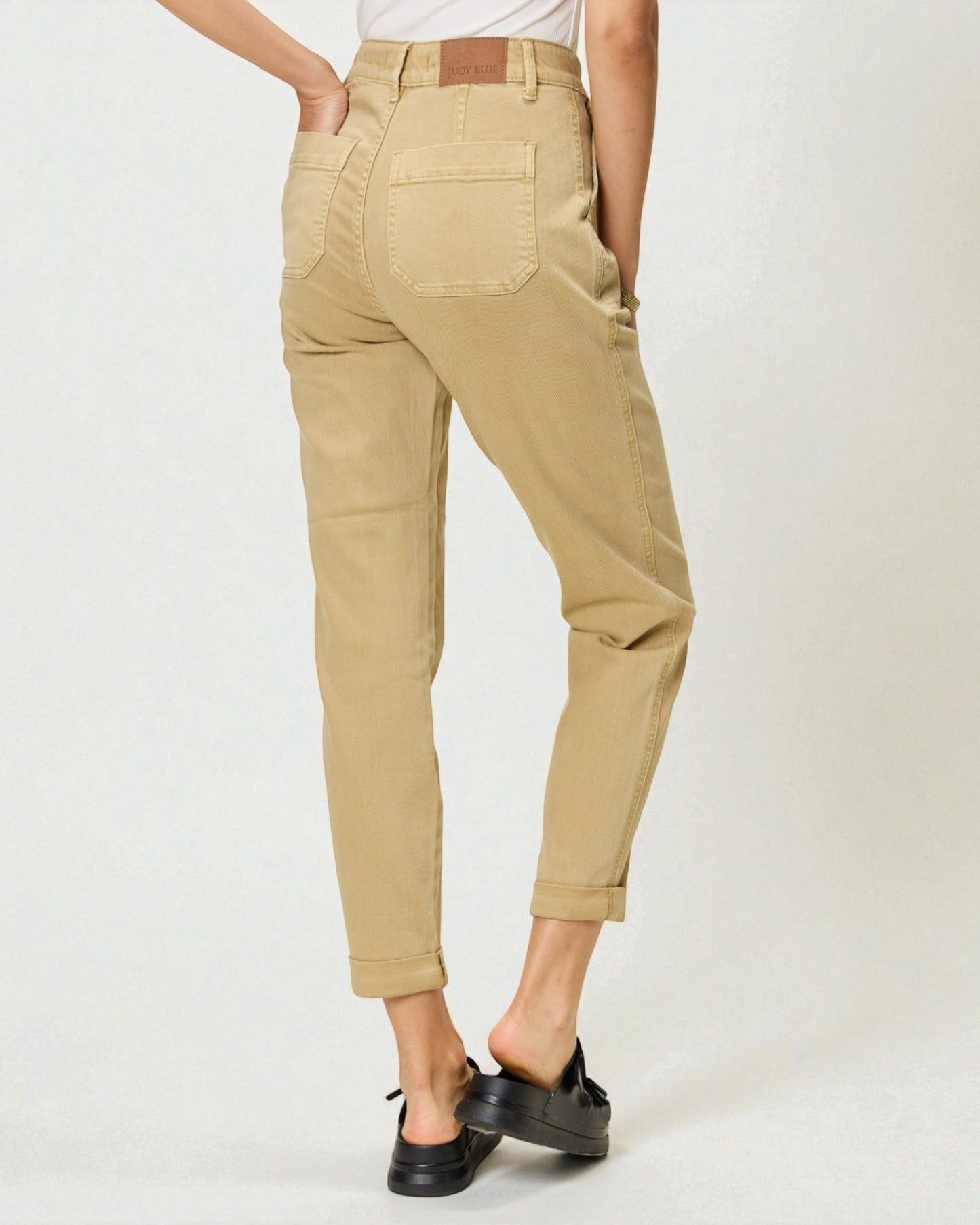 Person wearing beige pants on a white background