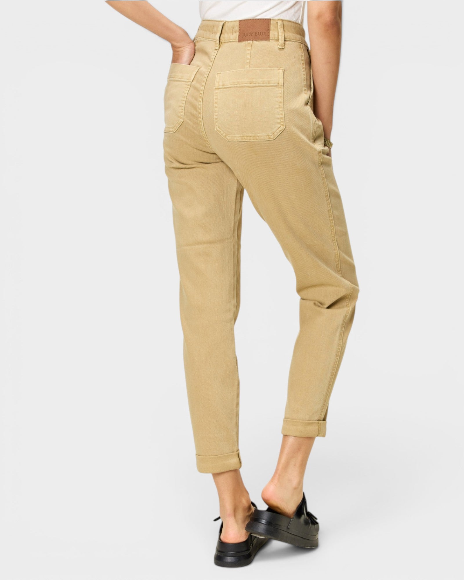 Beige pants worn by a person on a white background
