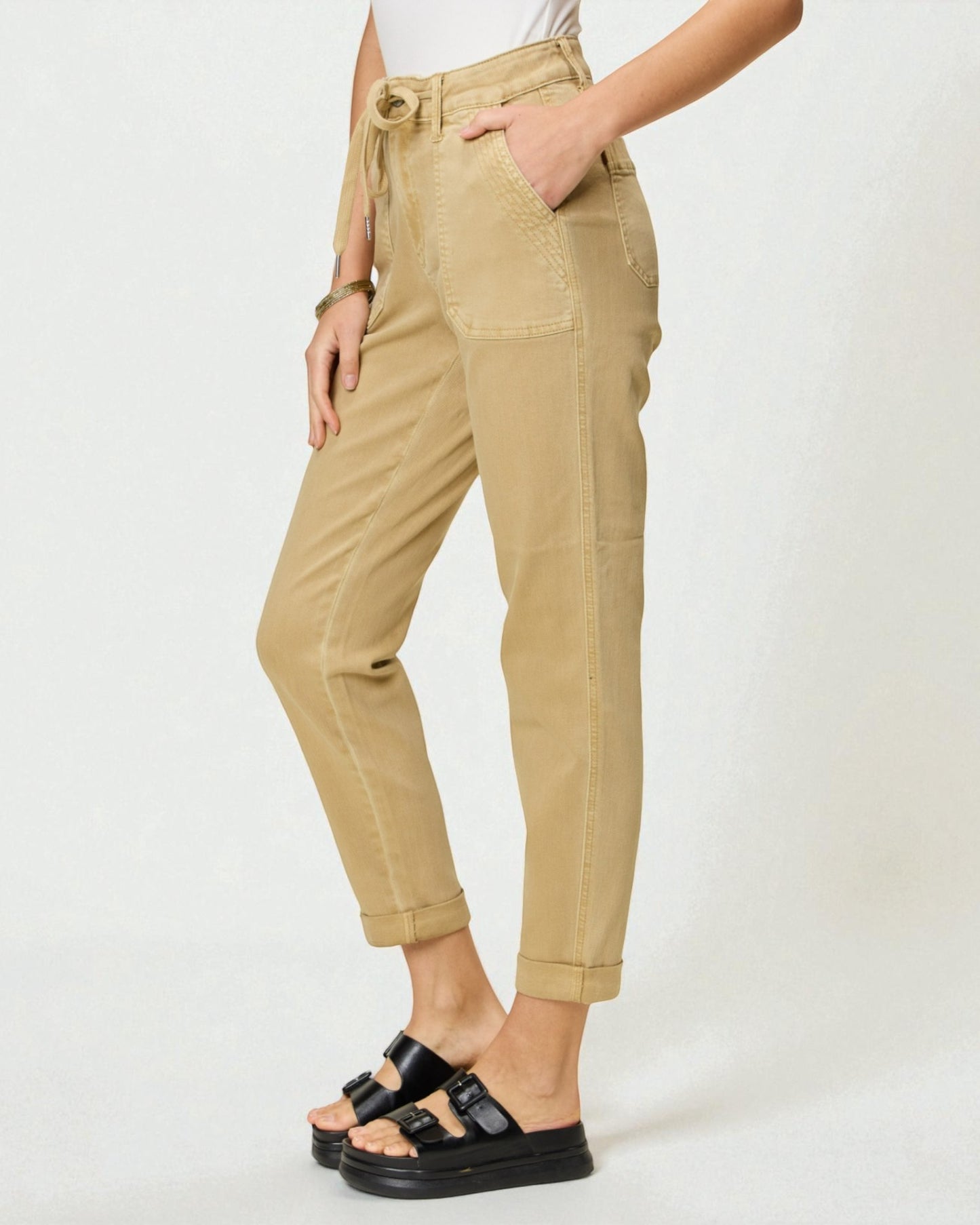 Beige pants worn by a person on a white background