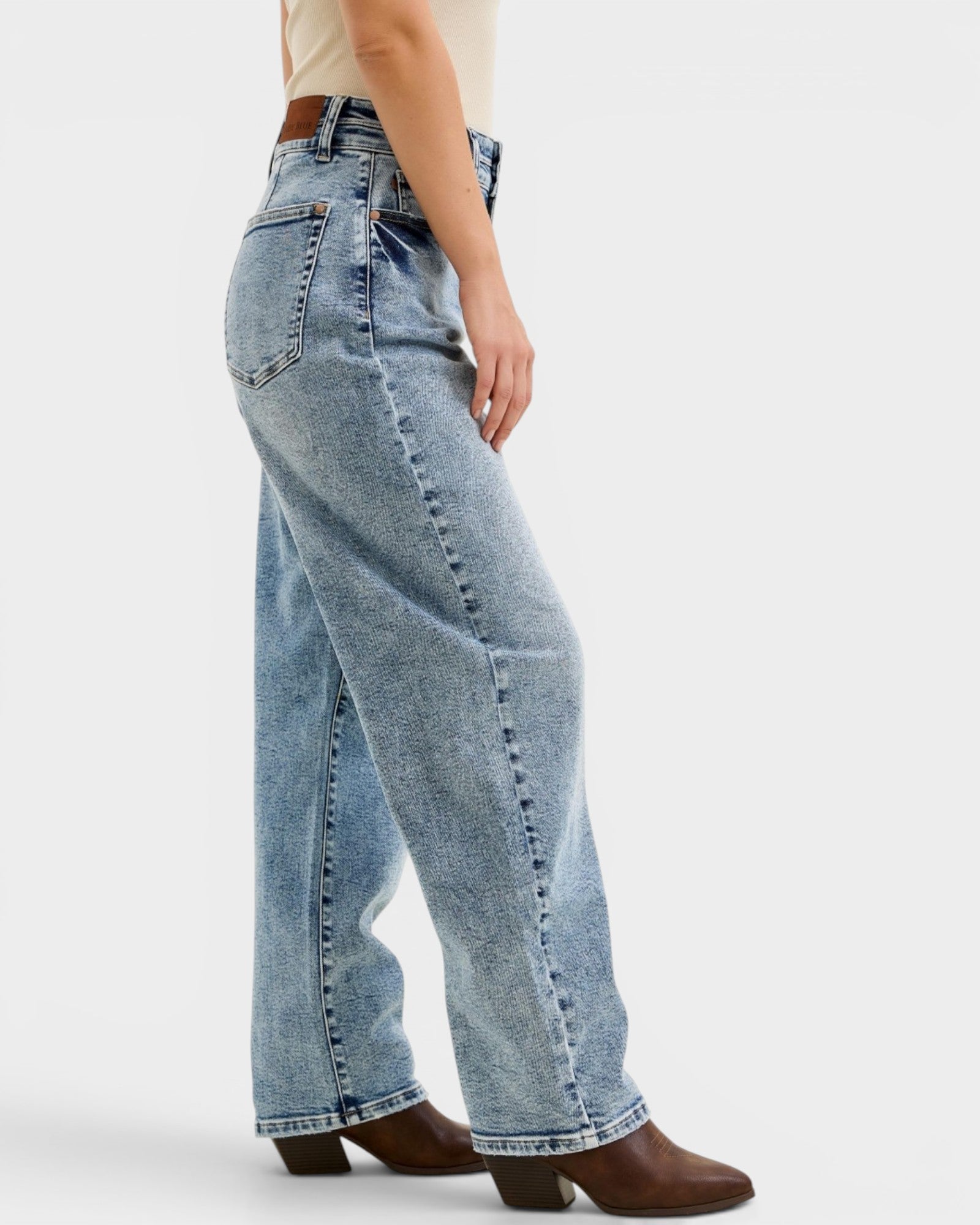 Person wearing light blue jeans on a white background