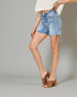 Person wearing denim shorts and a white top on a gray background
