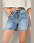 Denim shorts worn by a person on a neutral background