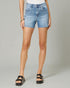 Person wearing light blue denim shorts on a gray background