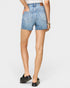 Person wearing light blue denim shorts on a white background
