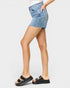 Person wearing a denim skirt and black sandals on a white background