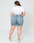 Person wearing light blue denim shorts and a white t-shirt on a plain background