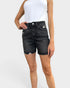 Person wearing black denim shorts on a white background