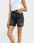 Person wearing black denim shorts on a white background