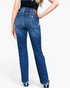 Rear view of a model wearing high-waisted blue denim jeans with a straight-leg fit, featuring a brown leather patch on the back waistband and subtle distressed details on the back pocket.