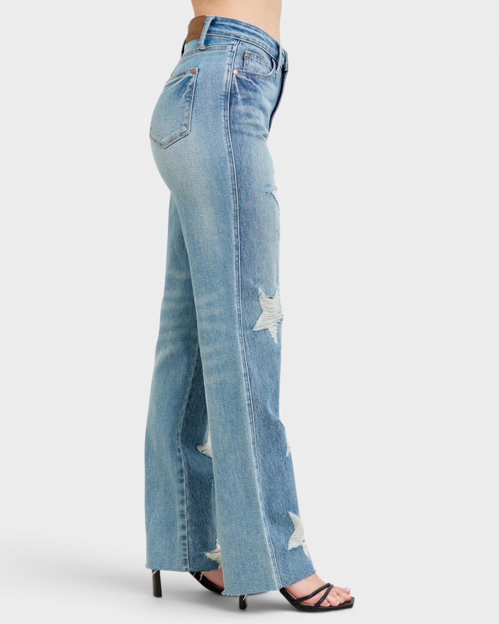 Light blue jeans with a slight distressed look on a white background
