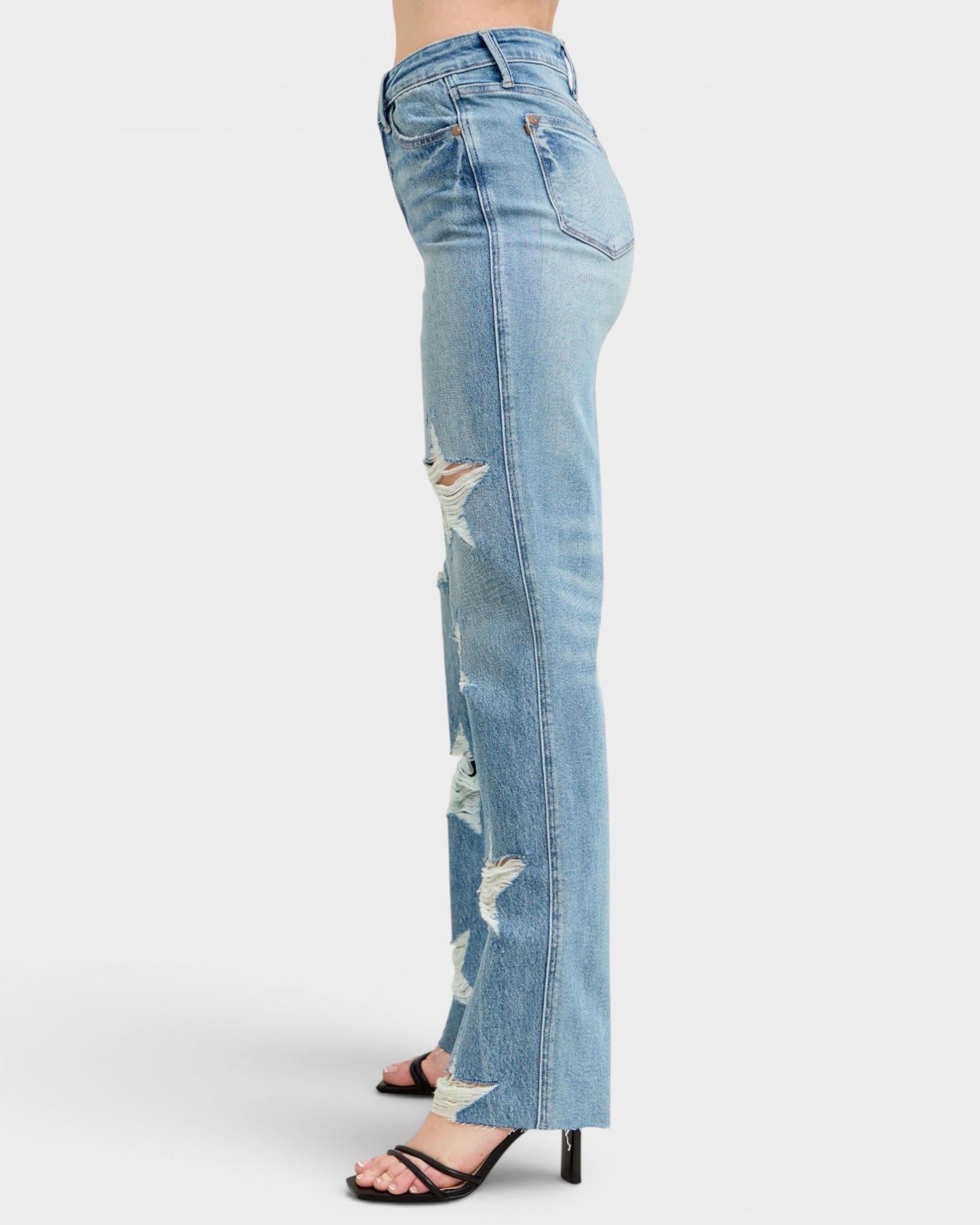 Light blue distressed jeans on a white background