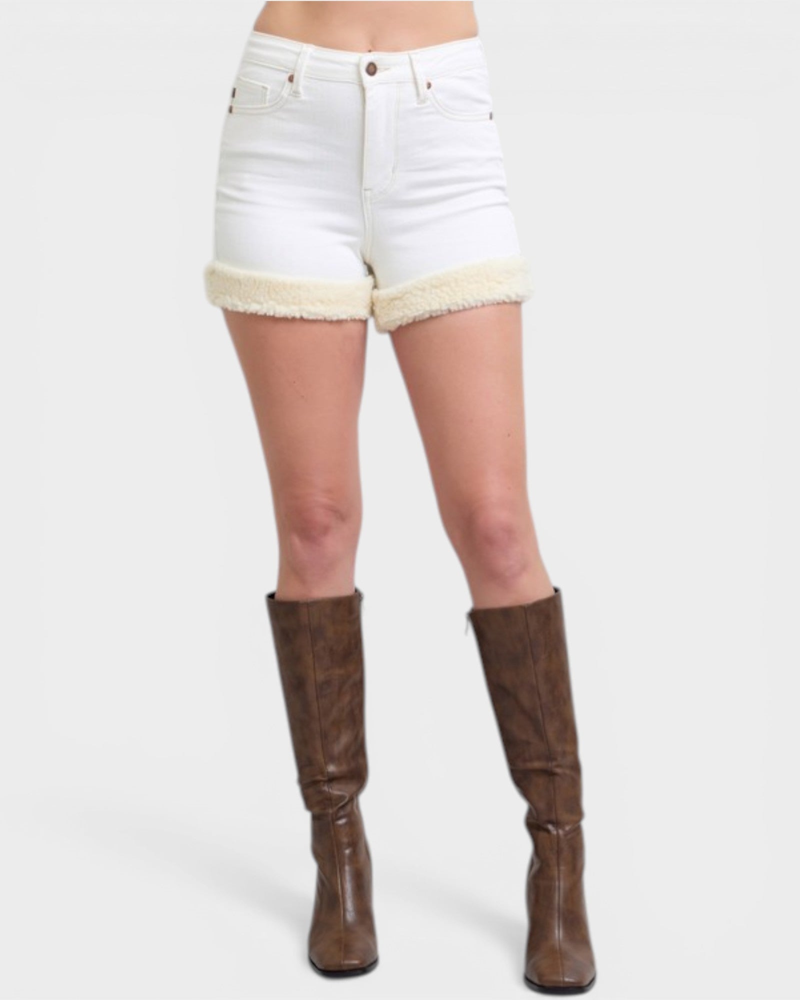 White denim shorts with beige trim worn by a person, paired with brown knee-high boots on a white background.