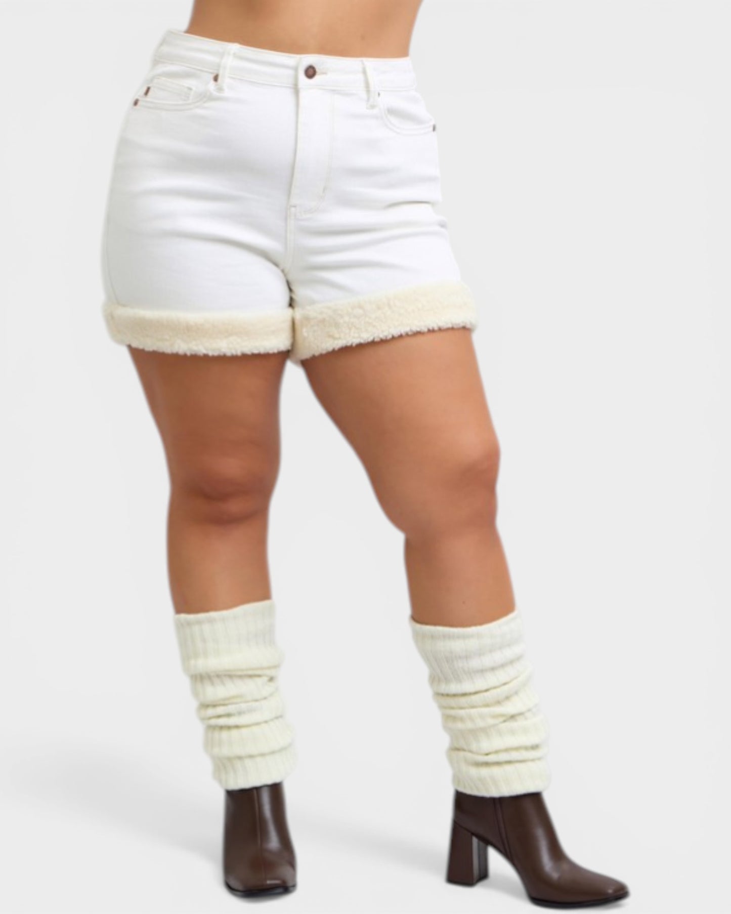 Person wearing white shorts with beige trim and brown boots on a white background