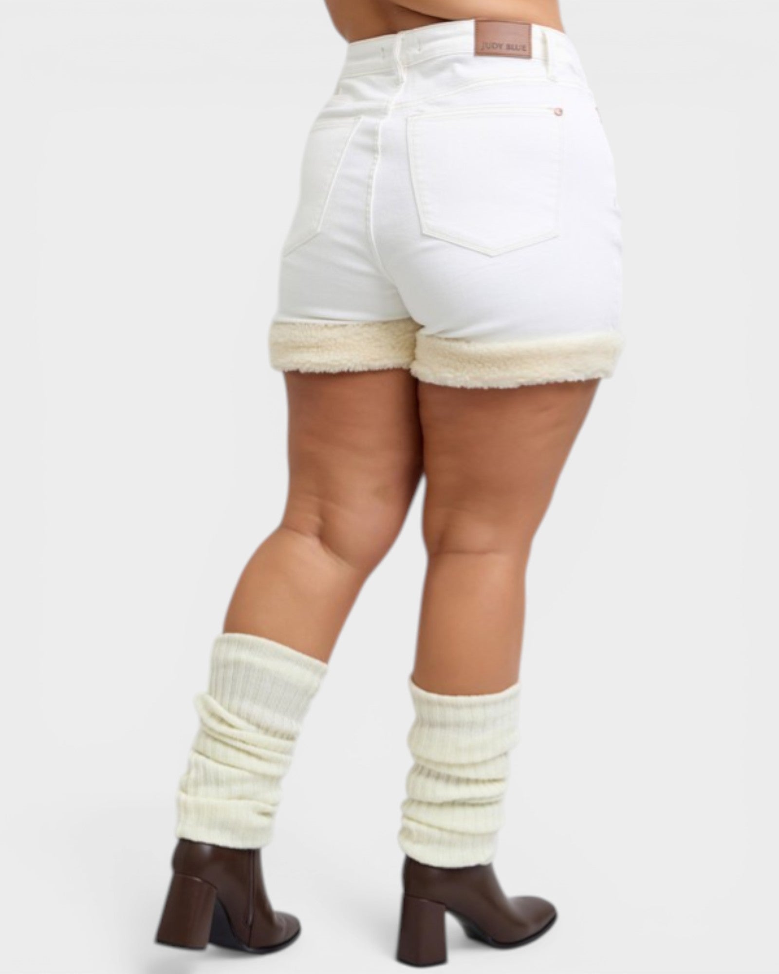 White shorts with beige trim worn by a person on a white background