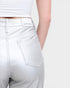 White jeans with a visible brand label on a plain background