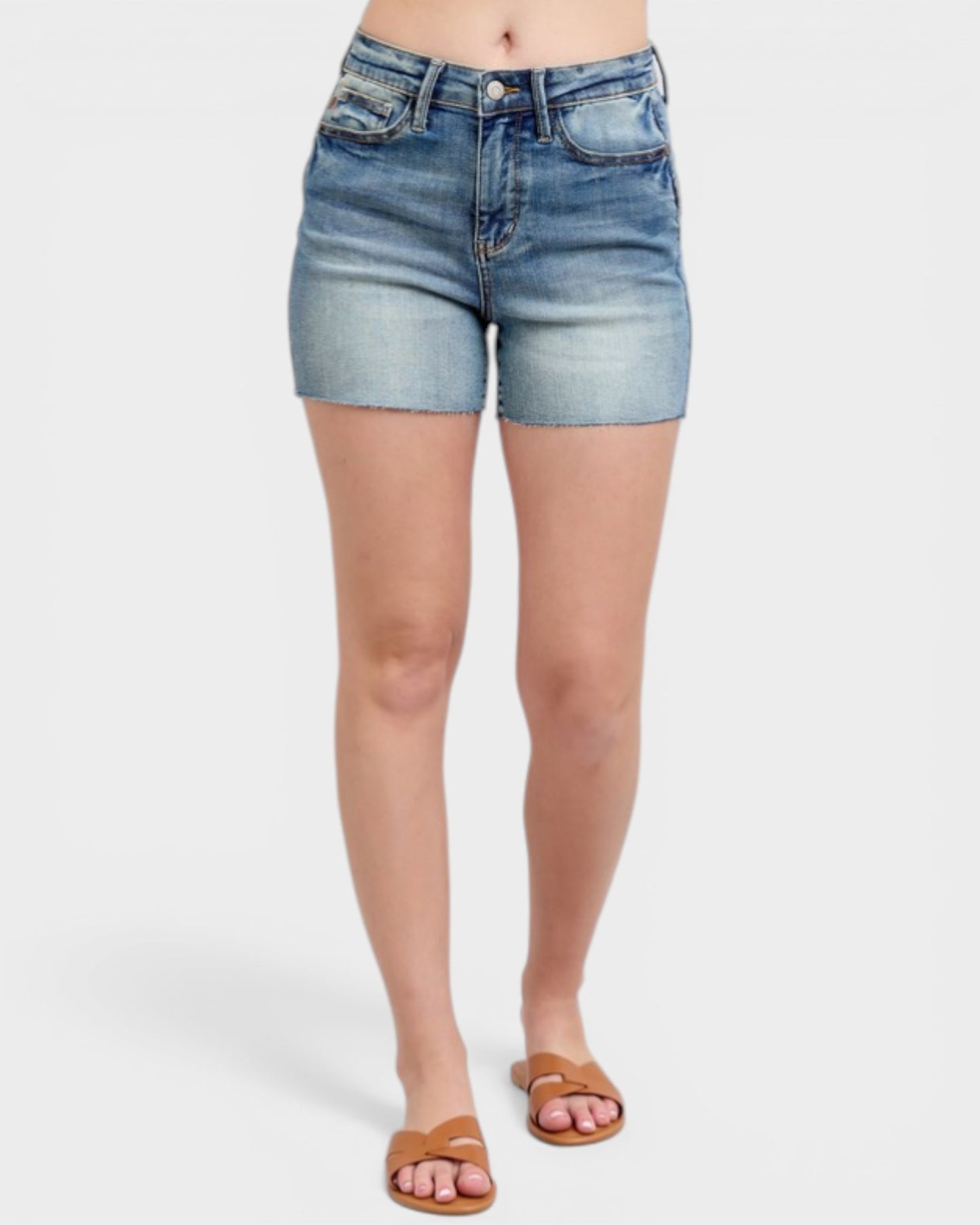 Denim shorts worn by a person on a white background