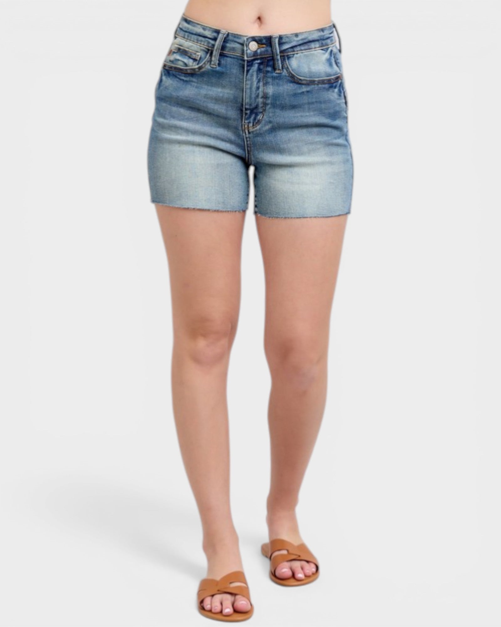 Denim shorts worn by a person on a white background