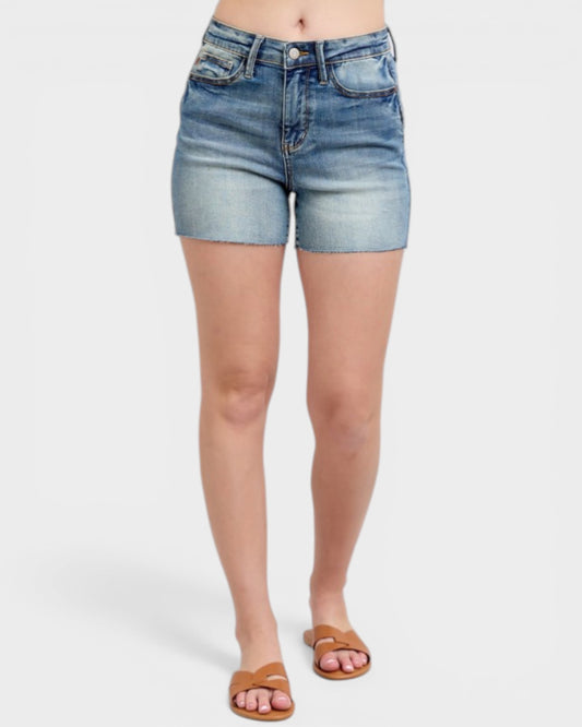 Denim shorts worn by a person on a white background