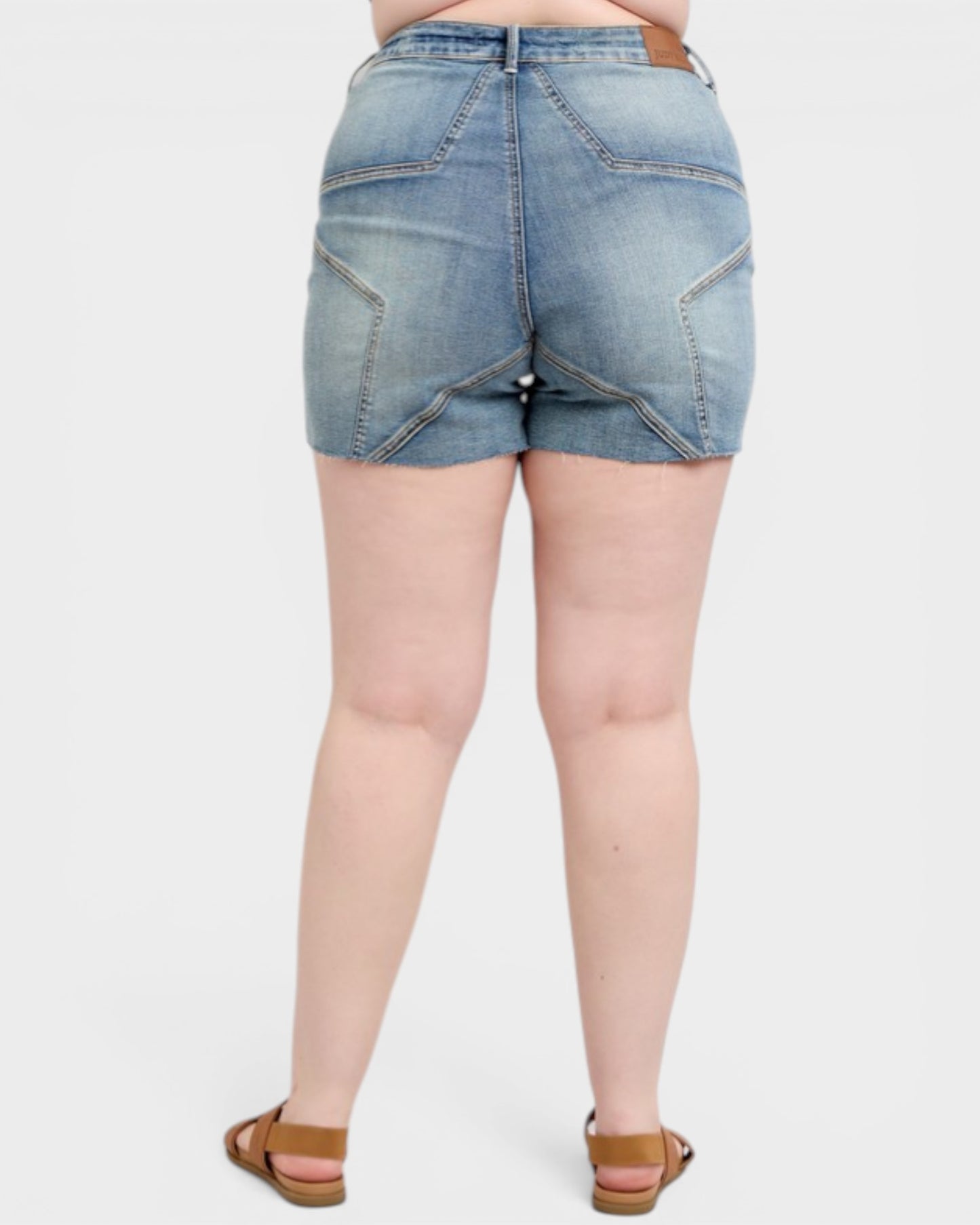 Denim shorts worn by a person on a white background