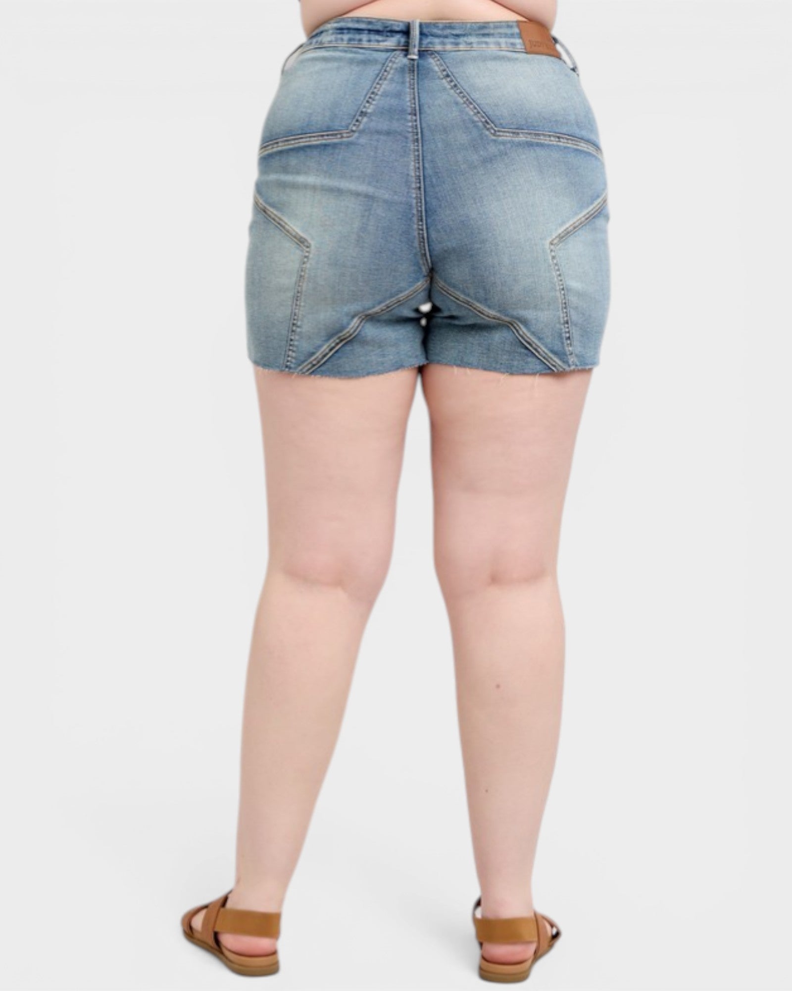 Denim shorts worn by a person on a white background