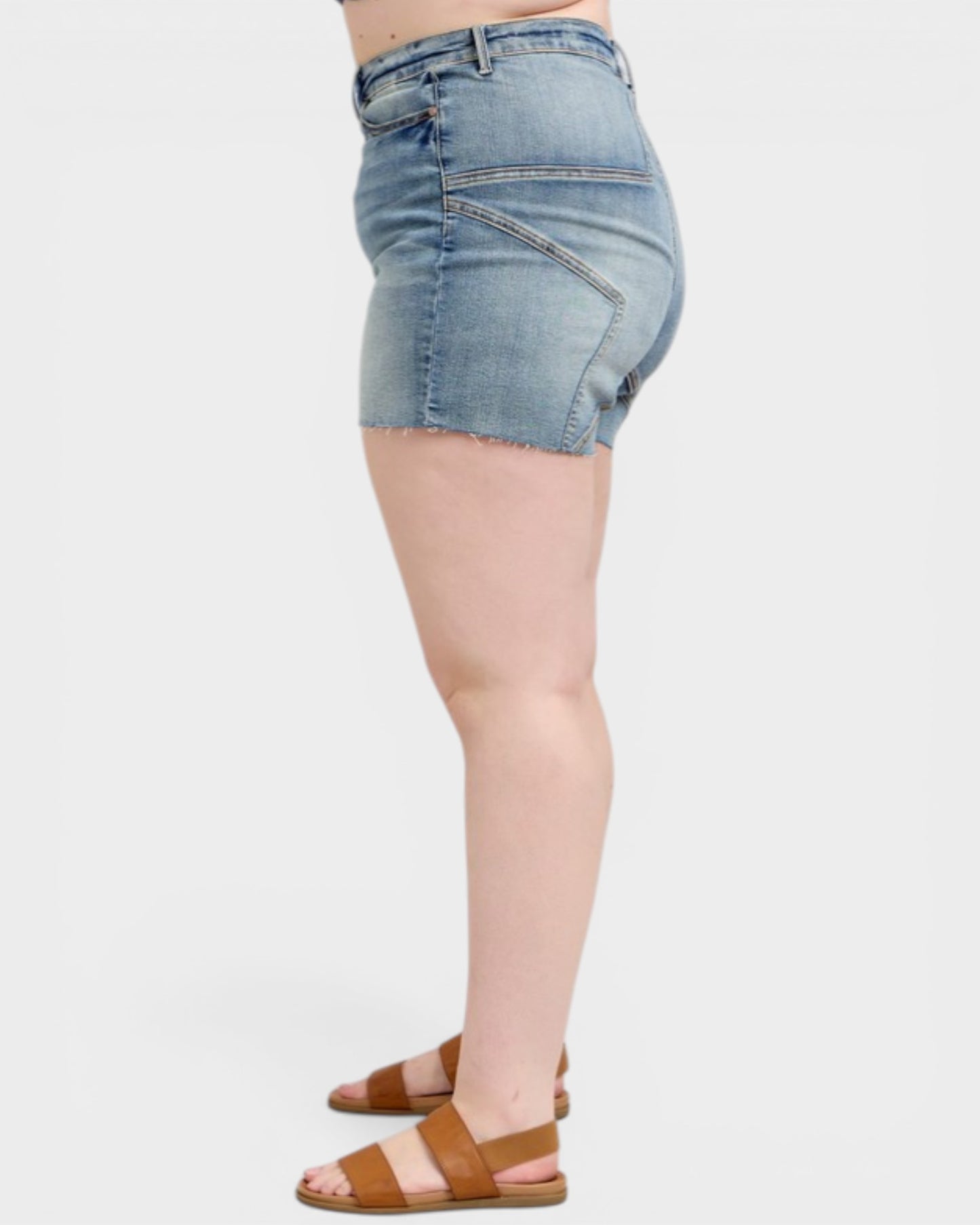 Denim shorts worn by a person on a white background