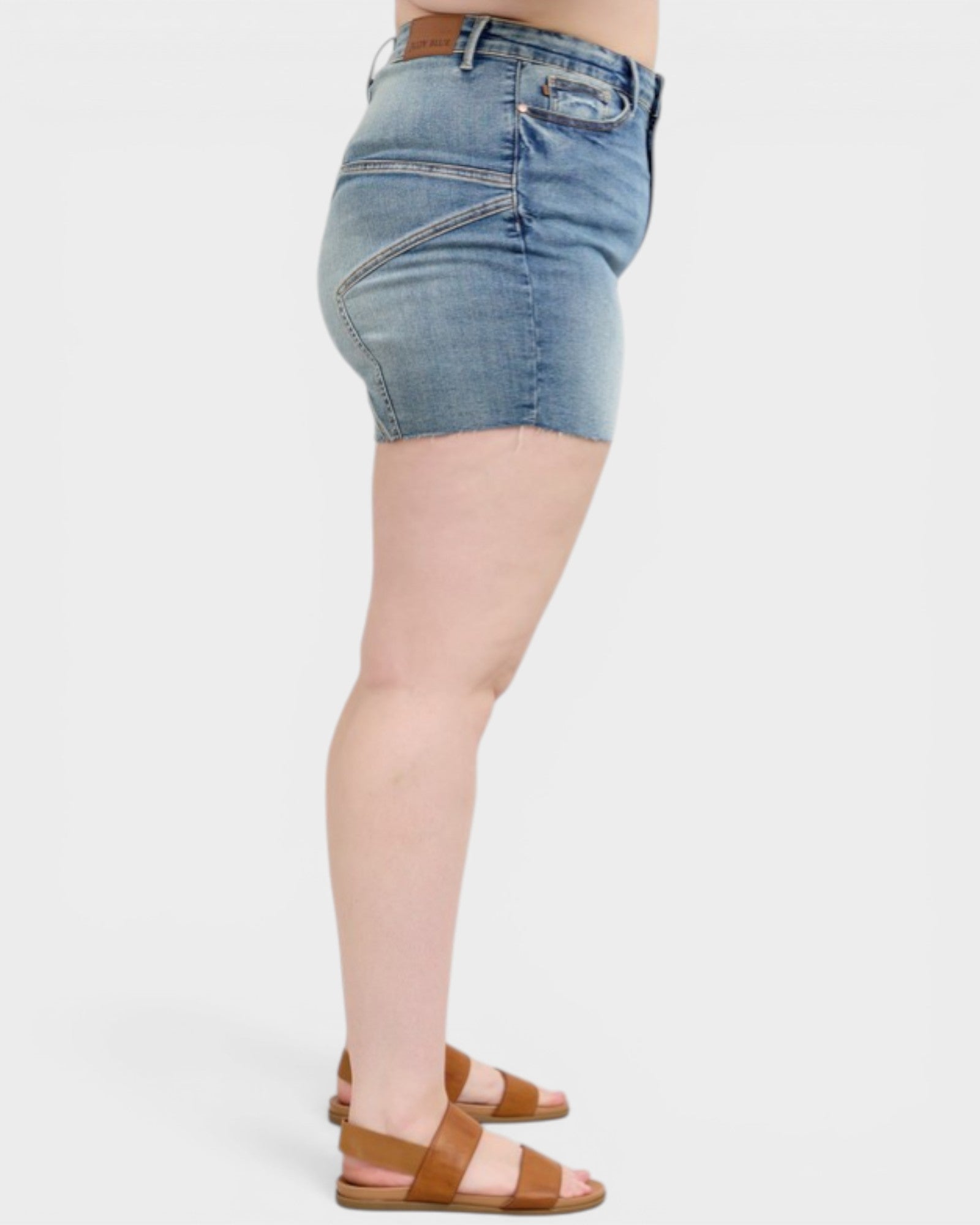 Denim shorts worn by a person on a white background