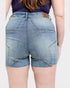 Person wearing blue denim shorts on a plain background