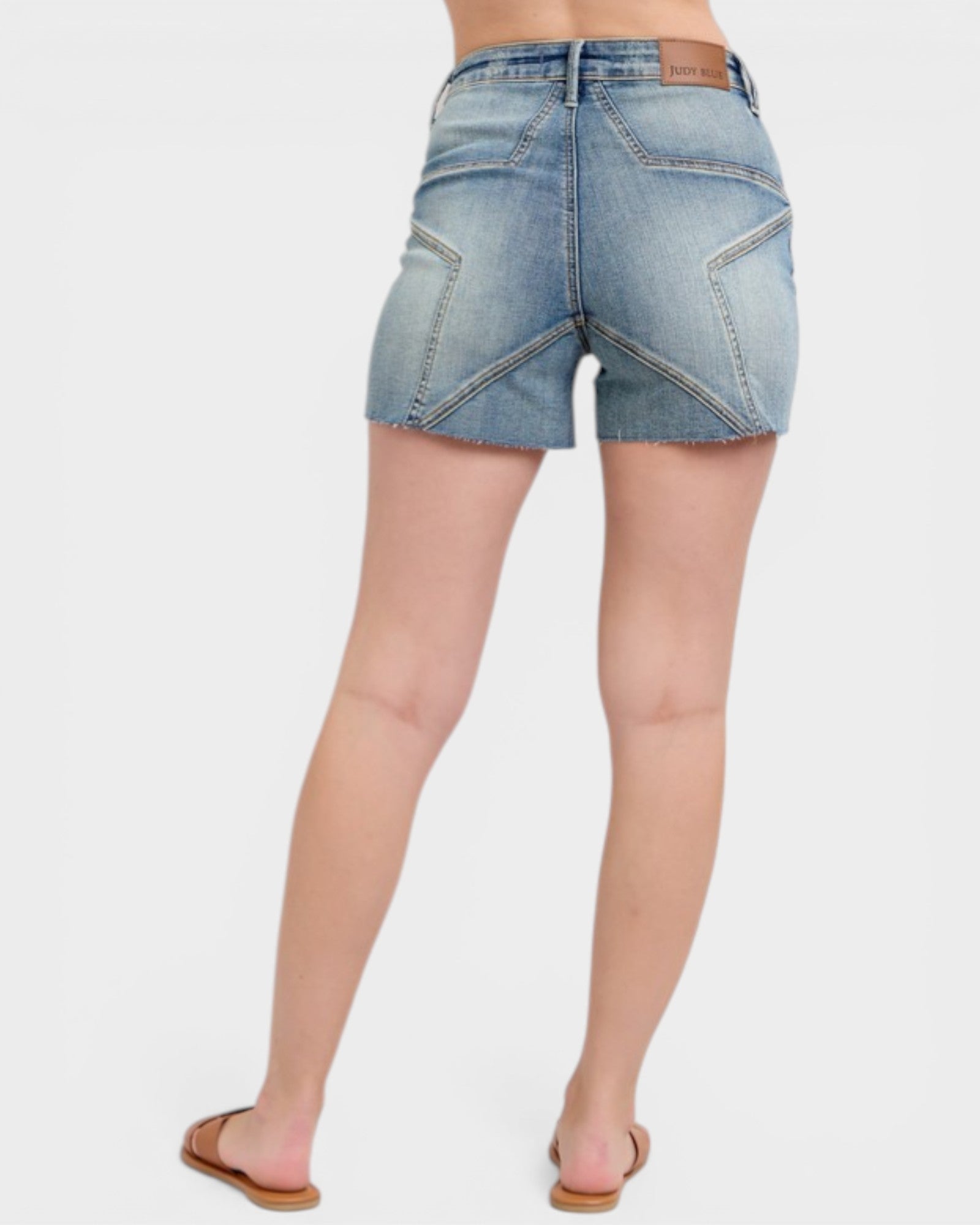 Denim shorts worn by a person on a white background