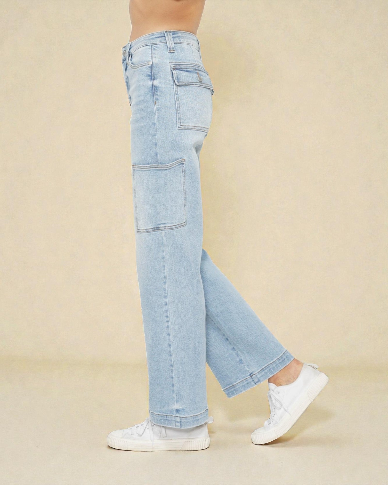 Light blue jeans worn by a person on a beige background