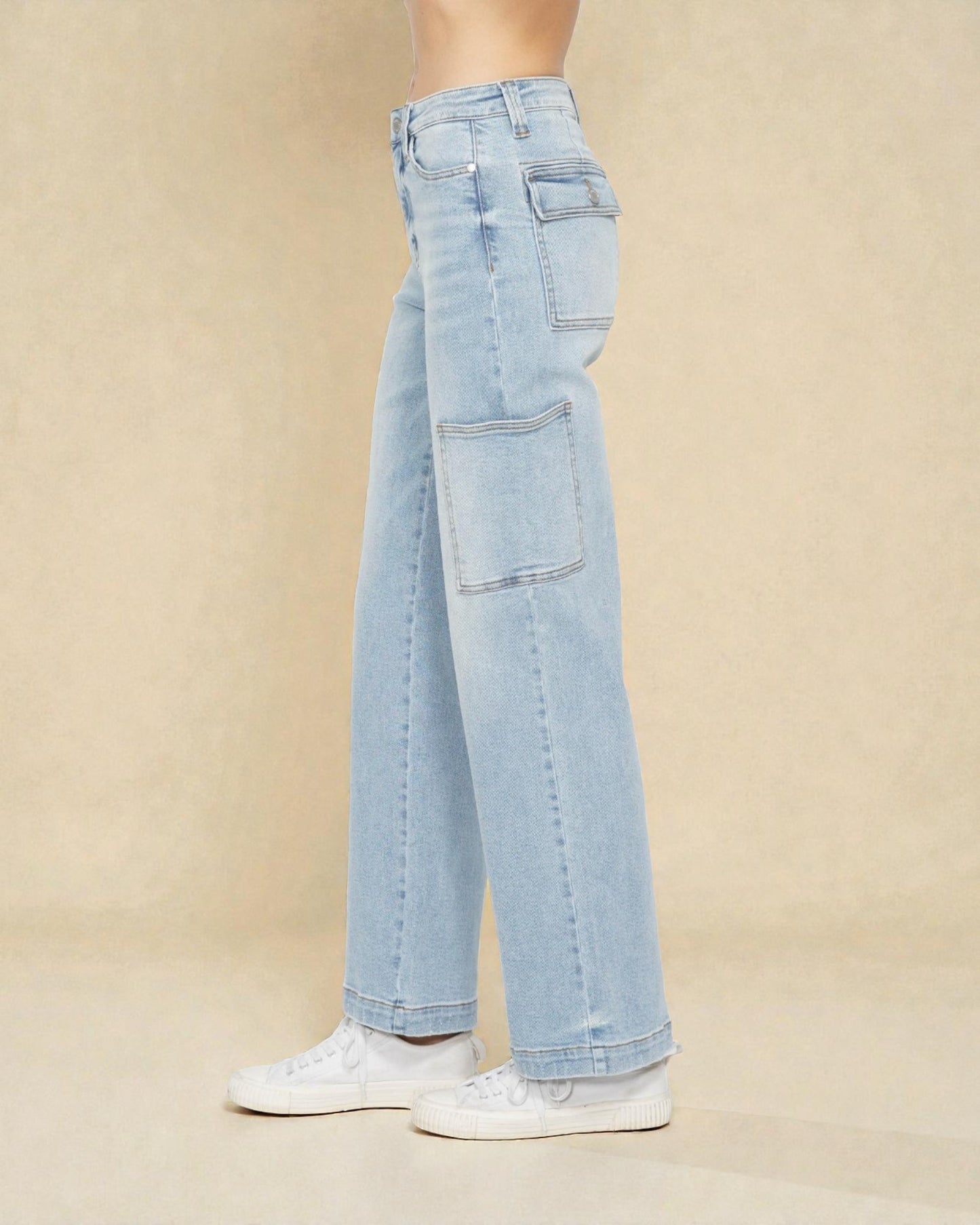 Light blue jeans worn by a person on a beige background