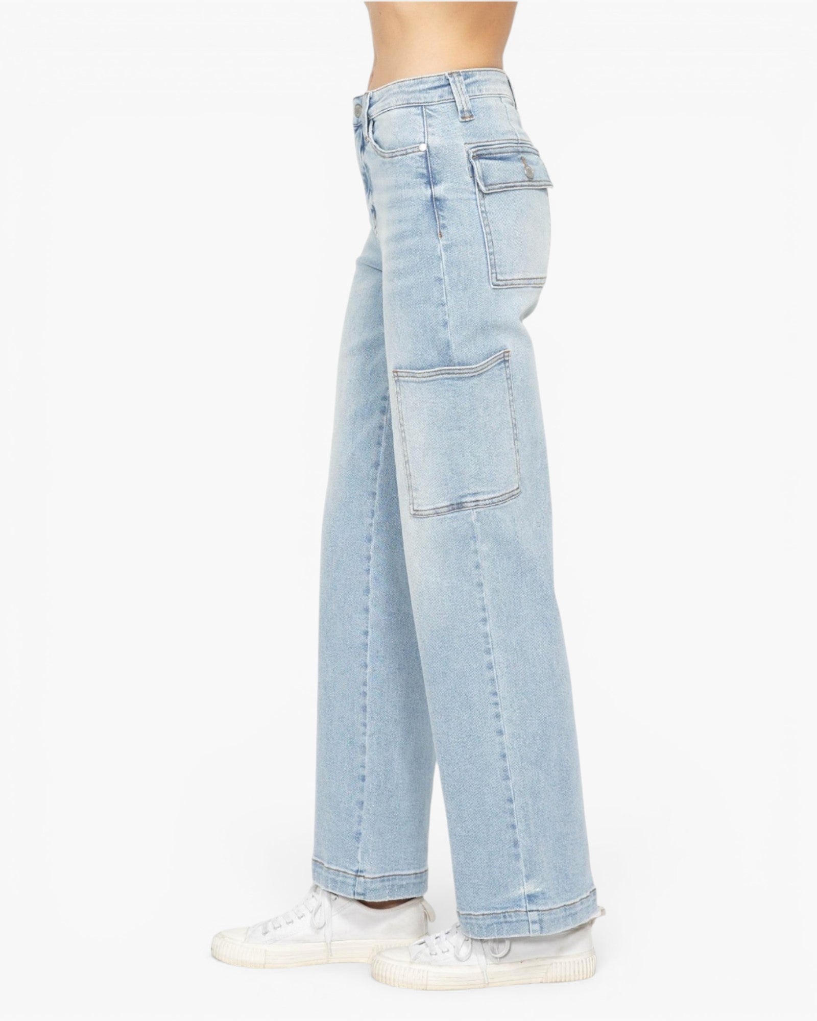 Light wash blue denim cargo jeans shown from the side on a model, paired with white sneakers against a plain white background.