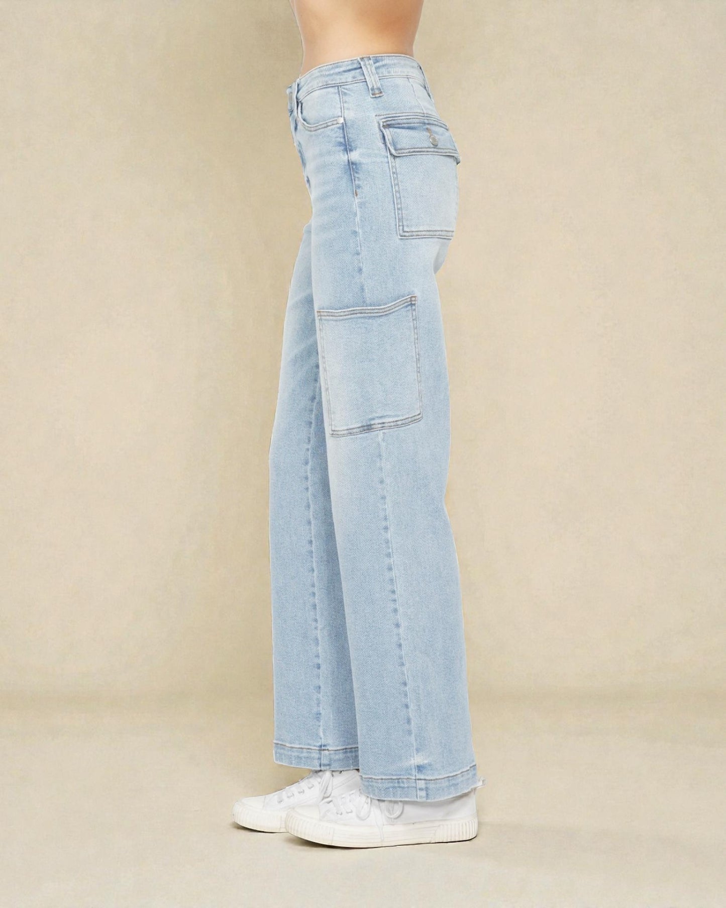 Light blue jeans worn by a person on a beige background