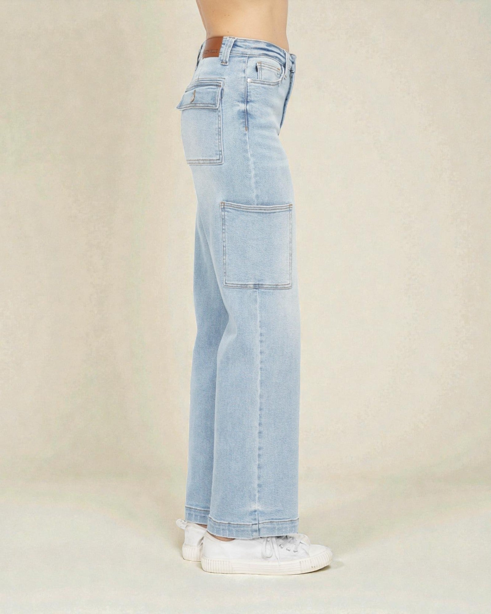 Light blue jeans worn by a person on a beige background