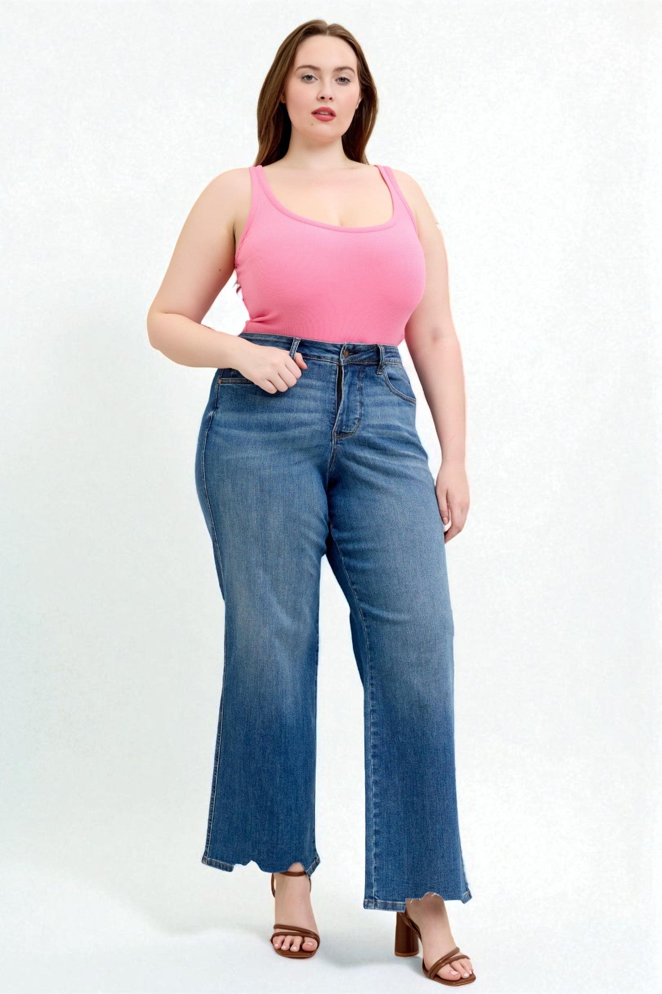 Woman wearing a pink top and blue jeans on a white background