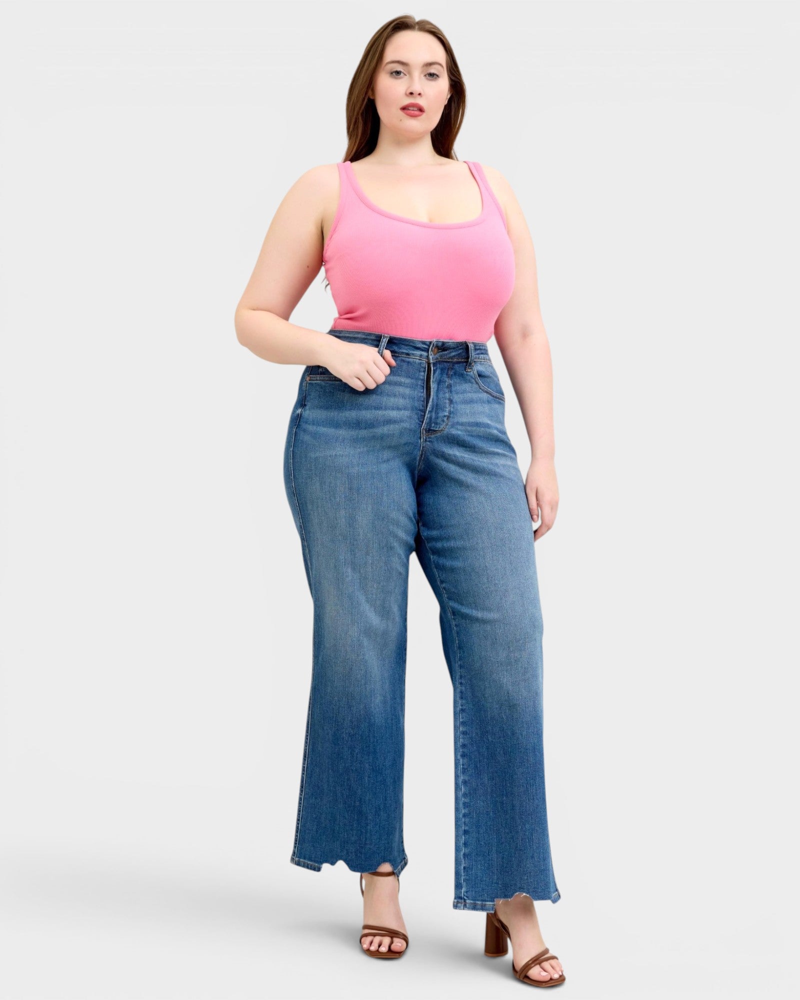 Woman wearing a pink top and blue jeans on a white background