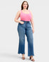 Woman wearing a pink top and blue jeans on a white background