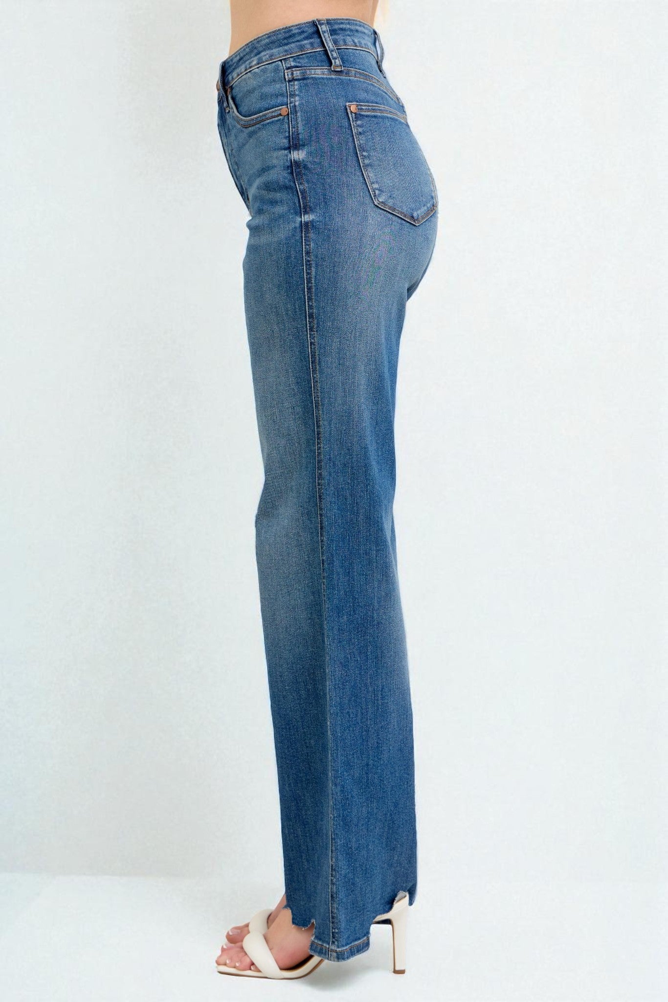 Blue jeans worn by a person on a white background