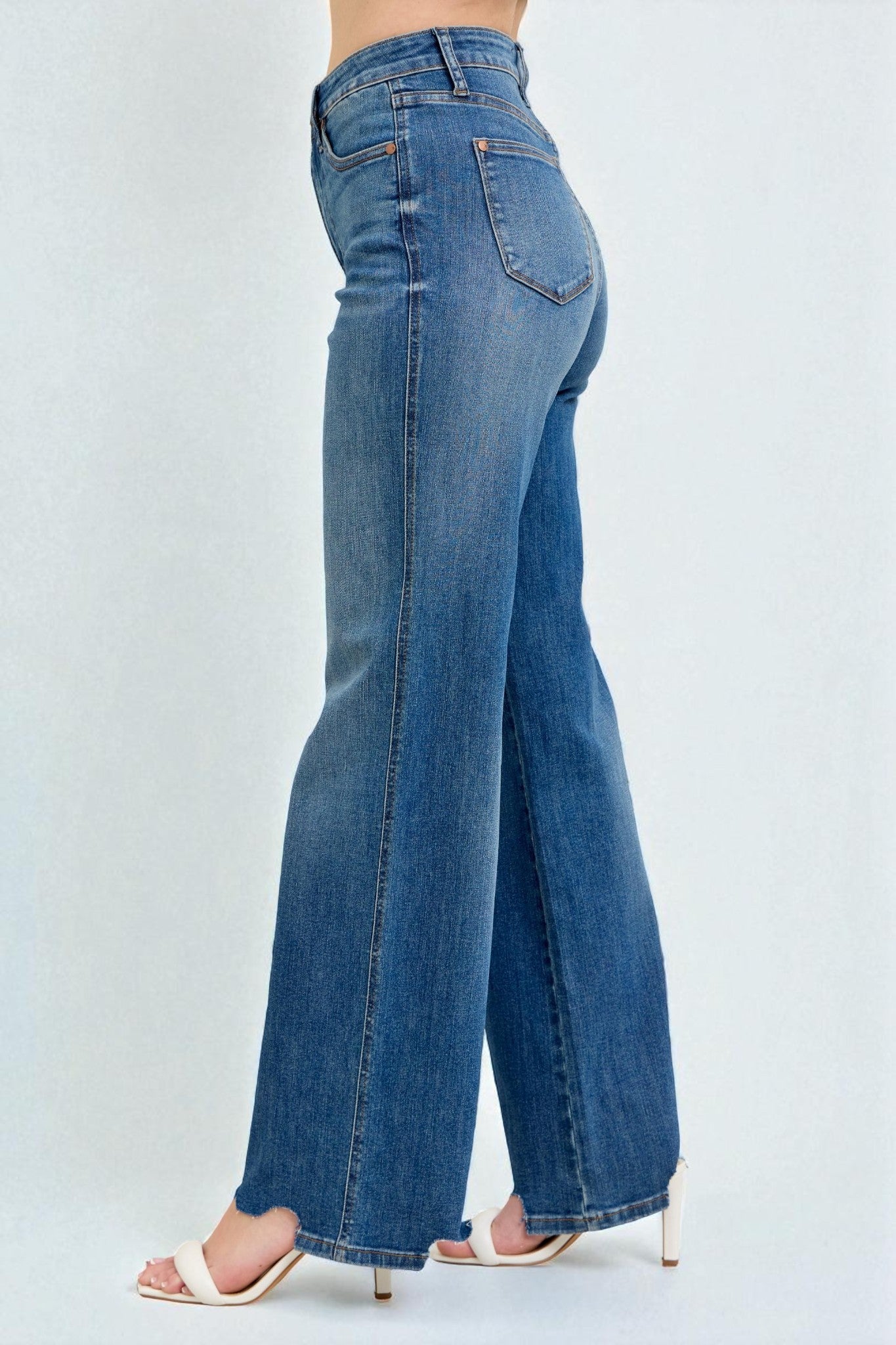 Blue jeans worn by a person on a white background