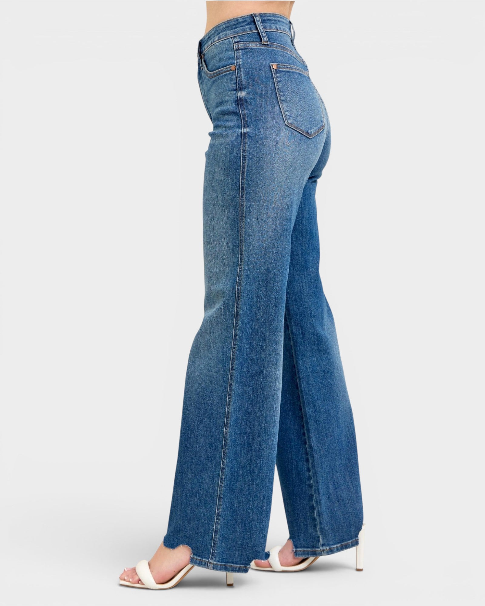 Blue jeans worn by a person on a white background