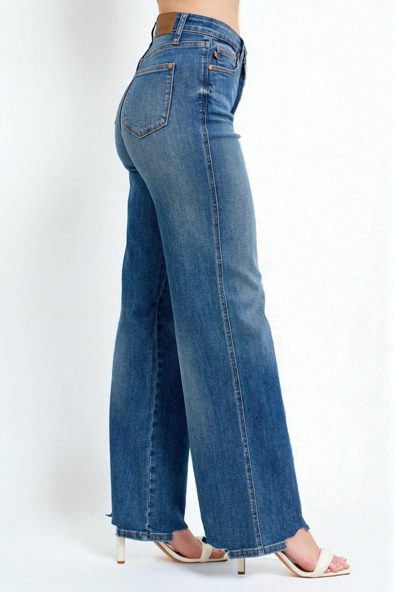 Blue jeans worn by a person on a white background