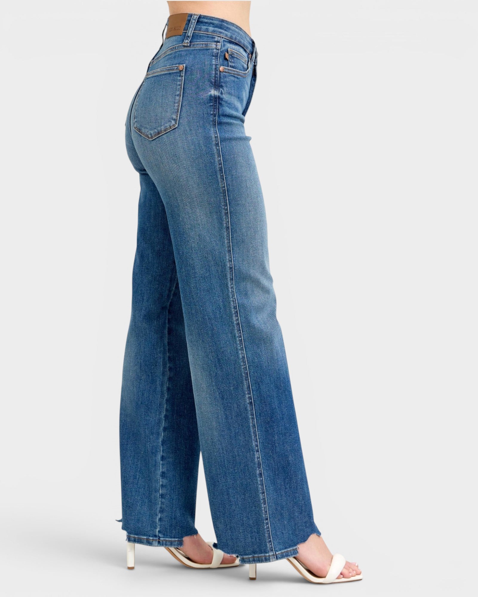 Blue jeans worn by a person on a white background