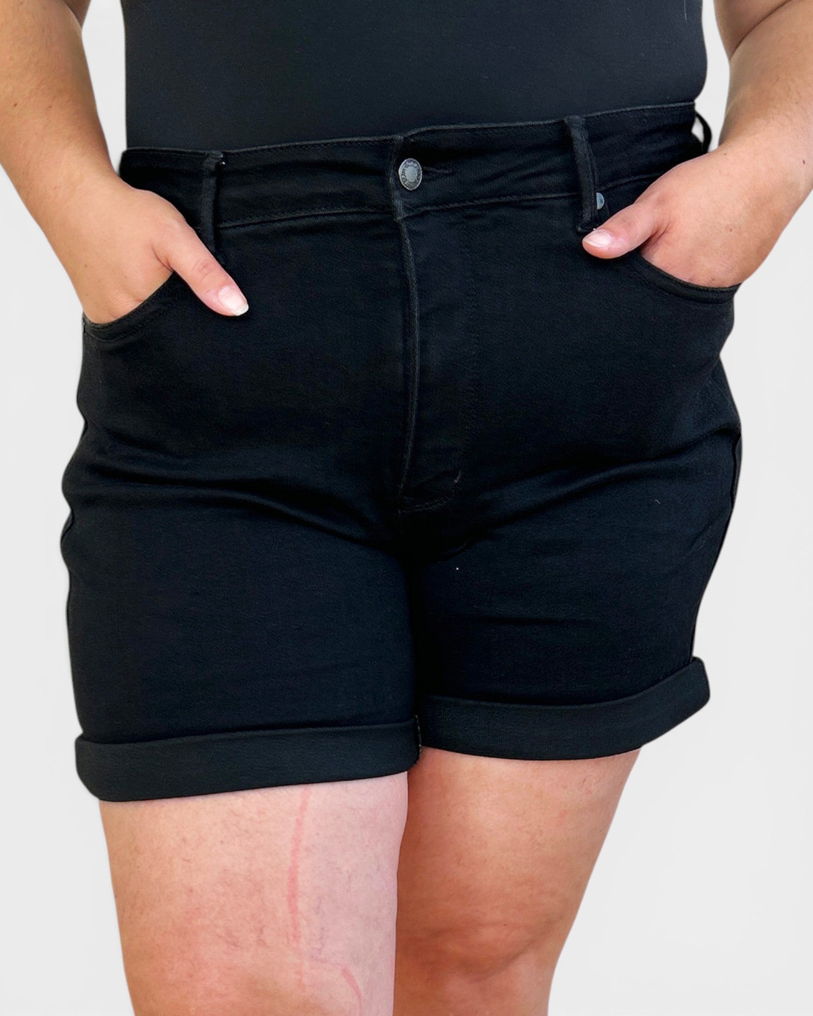 Person wearing black shorts on a plain background