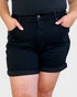 Person wearing black shorts on a plain background
