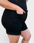 Person wearing black shorts on a plain background
