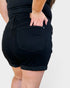 Person wearing black shorts on a plain background